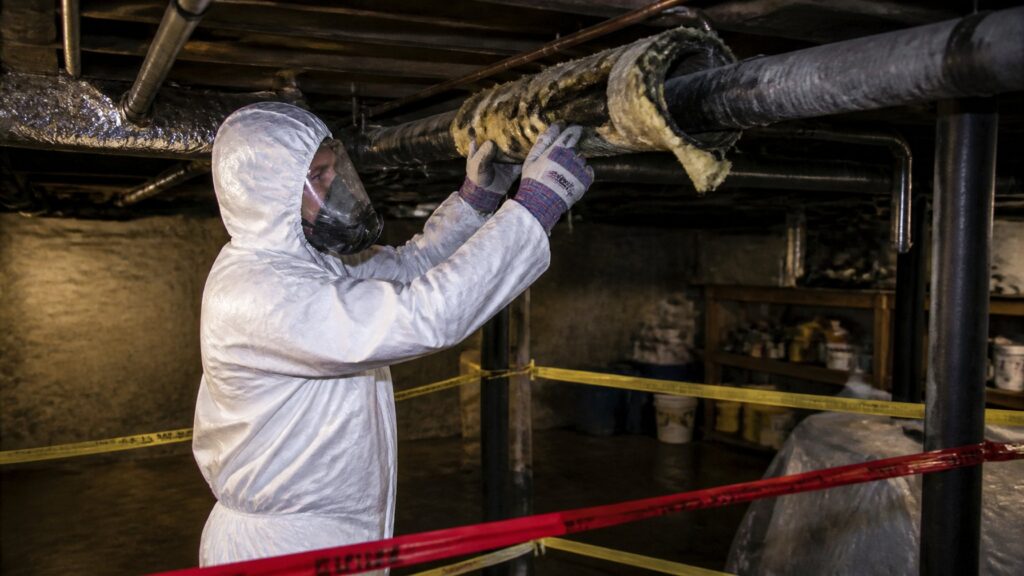 what do homeowners and contractors need to know about asbestos disposal in Illinois shown with licensed abatement worker in protective gear